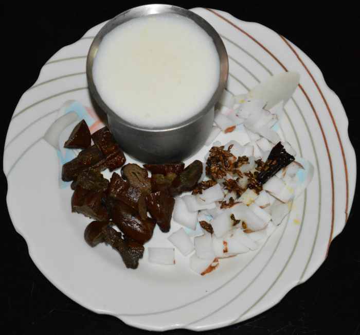 Step two: Add chopped pickled mangoes, grated coconut, roasted cumin, and broken dry red chili in a mixer or blender.