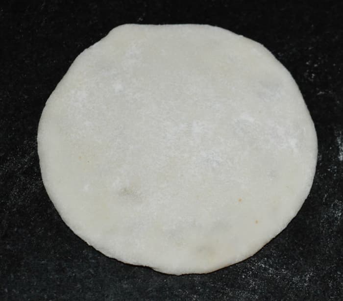Step four: Roll it in such a way that the stuffing will not come out. You can use all-purpose flour for the dusting. Make the discs of about 3 1/2 inches diameter. Make all of the discs and keep them ready.