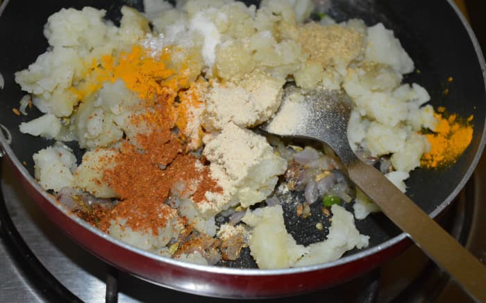 Step three: Add mashed potato. Add all the spice powders, salt, and sugar, as per instructions. Mix well. Saute for two minutes. Turn off the heat. Onion potato stuffing is ready. Let it cool down.
