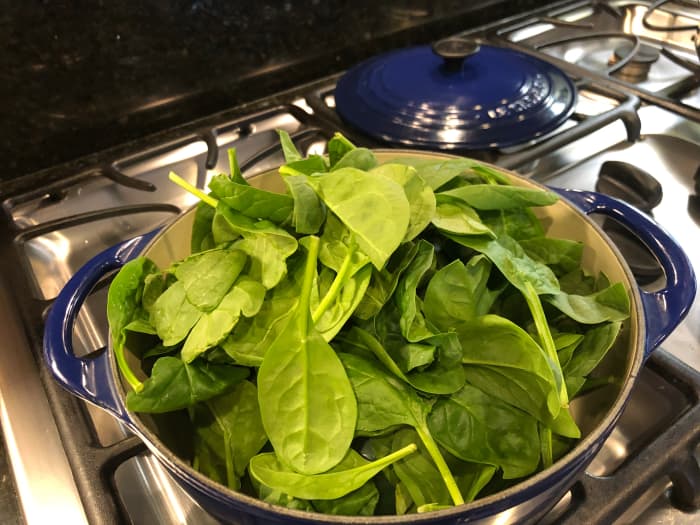 It may seem like the spinach won't fit in the pot, but it cooks down significantly as the leaves wilt.