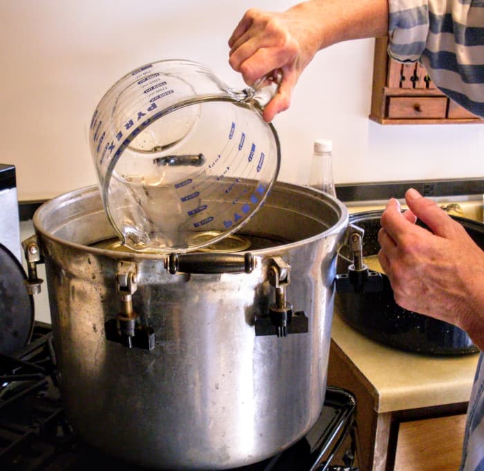 Pour into your pressure canner the recommended amount of water (usually 2 quarts), and begin heating it.