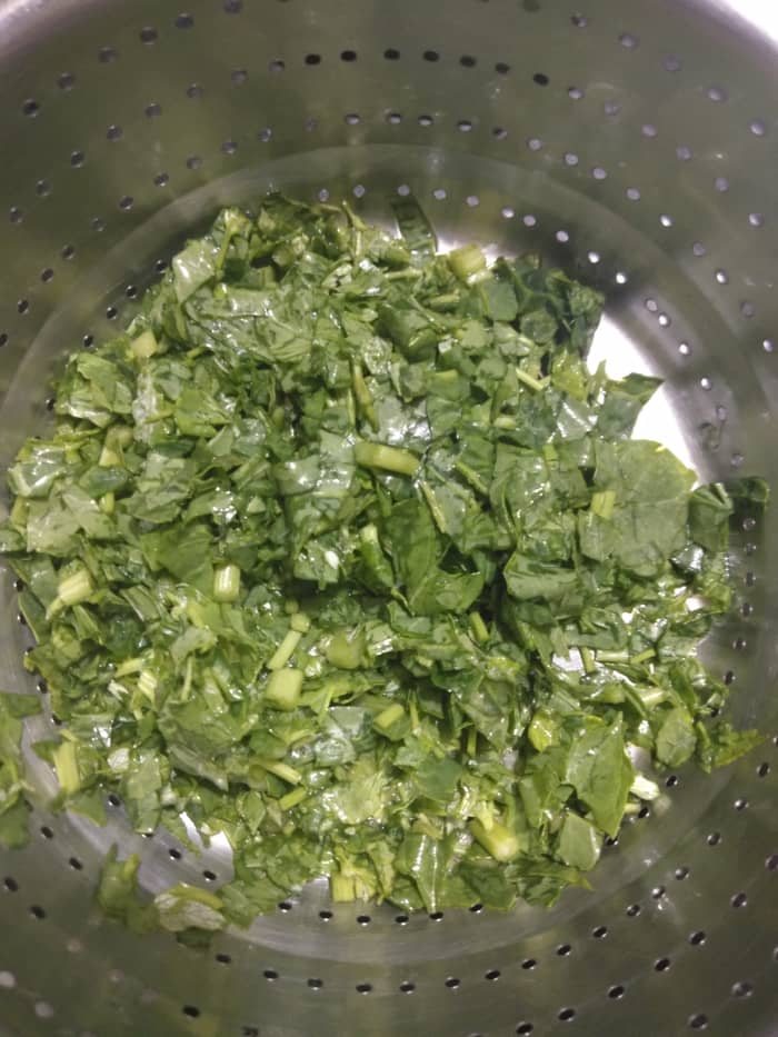Chop the leaves and stems (only use the tender stems) of the bathua plant. Rinse well and drain the water.