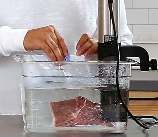 Once the water is heated to the adequate temperature, you may immerse the bag inside the pot and clip the two ends to the side of the pot.
