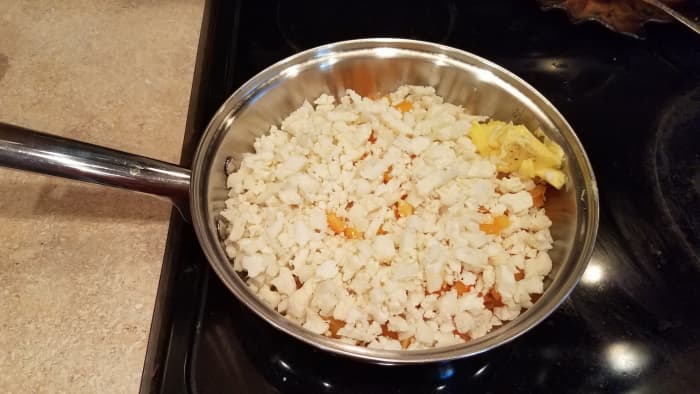 Start by chopping all of your veggies and cooking them in butter in a pan on the stove over medium-high heat.