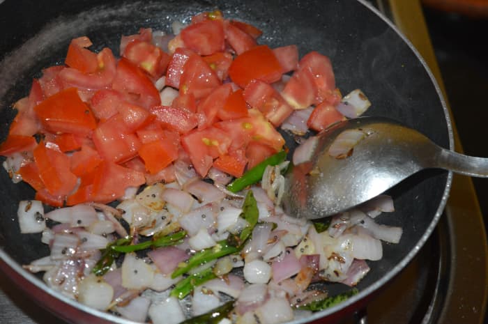 Step four: Add chopped tomatoes. Saute for 2 to 3 minutes. Next, add 2 cups of water. Cover the pan and cook until tomatoes turn a bit mushy.