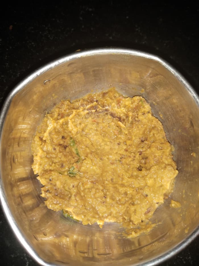 Add salt and grind to a fine paste without adding water. Add seasoning, garnish with coriander leaves, and serve.