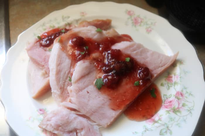 Drizzle the warm ham slices with the Cherry Champagne Sauce, and serve with additional sauce on the side for passing.