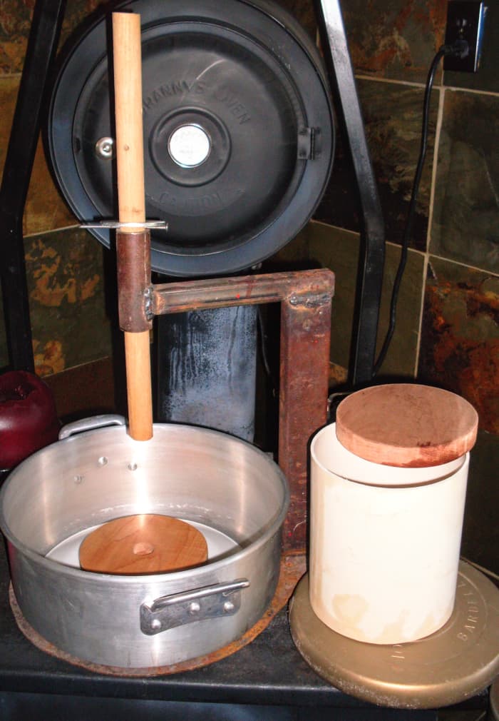 The components of my cheese press are something any do-it-yourselfer and someone with welding experience can make. (For the curious, that's a “granny oven” on a wood-burning stove behind the press.)