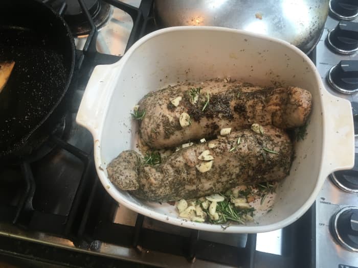 Fill a large oven-safe casserole dish with a mixture of the peeled and chopped onions, rosemary, and the meat.