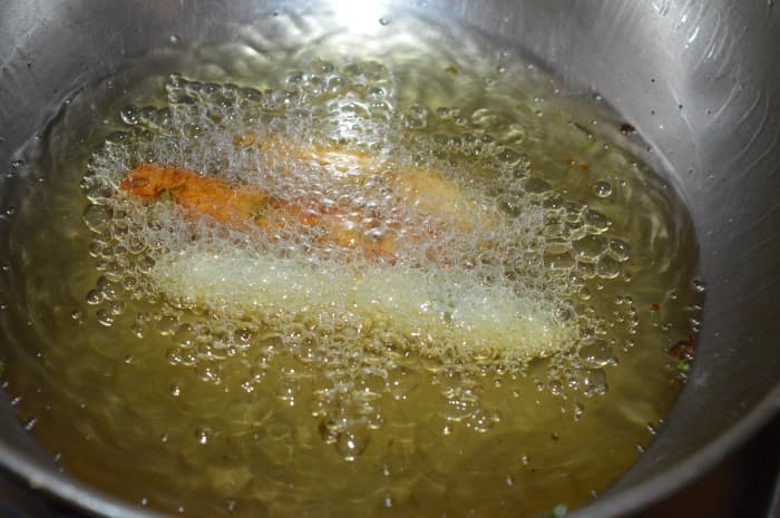 Step four: Make your fingers oily. Take a small portion of the dough in your fingers. Press it and make a round shape. Elongate to make a cylinder shape. Slide it in hot oil. Dep-fry it.