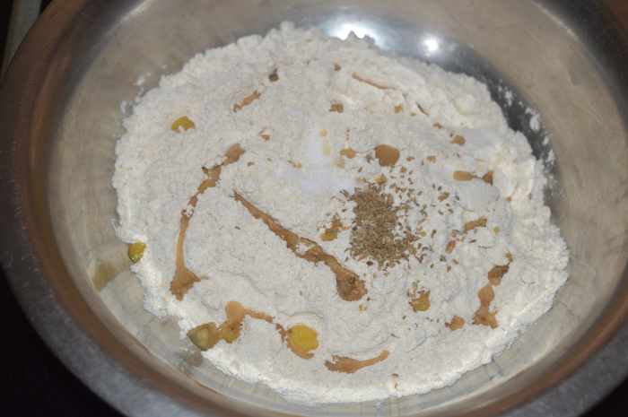 Step one: Add wheat flour, oil or ghee, salt, and carom seeds to a mixing bowl. Knead, adding water as needed to form a firm and pliable dough.