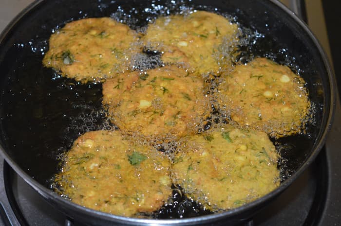 Step four: Prepare 5 to 6 such shapes and place them on a plate. Gently slide them into the hot oil. Keep heat medium high. Turn them after a minute or once the outside of the patties become firm.