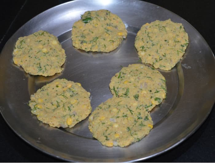 Step three: Take a lemon-sized piece of dough and make a ball out of it. Keep it between your palms and gently press to make a round patty. Heat the oil for deep-frying.