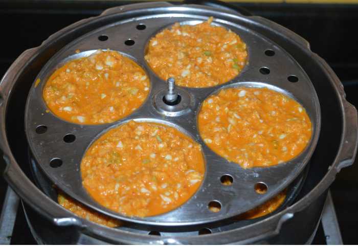 Place the idli stand inside the steamer or cooker. If using a pressure cooker, there's no need to place the weight. Cook over medium-high heat for about 15 minutes. Turn off the heat and open the lid. Take out the idli stand. Allow it to cool.