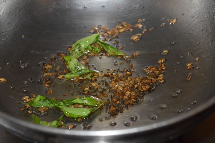 Step 1: Heat oil in a deep-bottomed pan. Add mustard seeds. Allow them to crackle. Throw in cumin seeds and curry leaves. Saute for 10 seconds. Reduce heat to minimum.