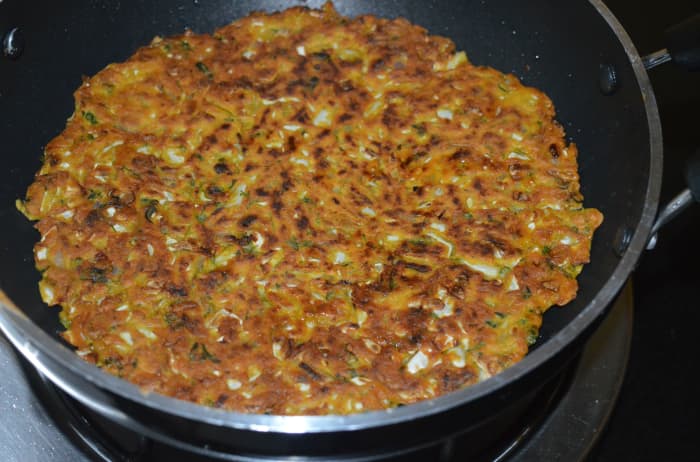 Step three: Cover the pan and cook for 6-7 minutes. See whether the pancake has become roasted on the bottom. If not, continue cooking. Flip it. Add some oil on the top side of the pancake.