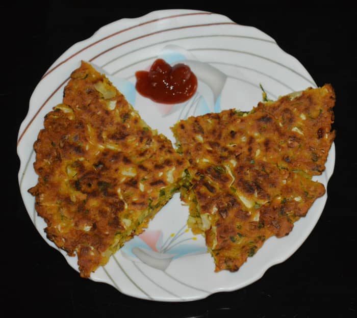 Now, you will get the cabbage pancake on the plate. Cut it in your desired shape. Serve hot with tomato sauce. Enjoy!