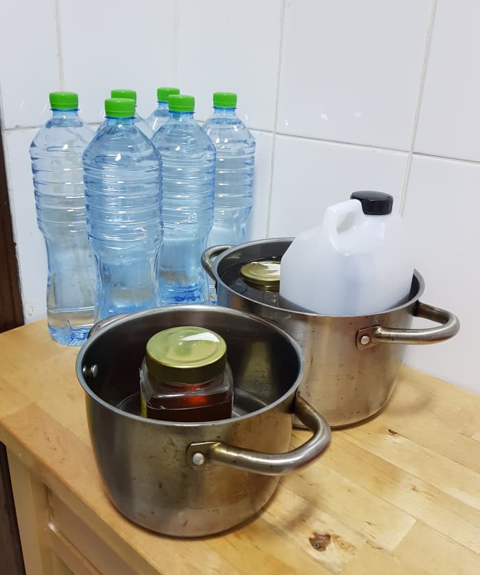 Make the honey more fluid by warming it up. Boil a large pot with an inch or two worth of water. Place honey containers into the hot water. Let them rest.