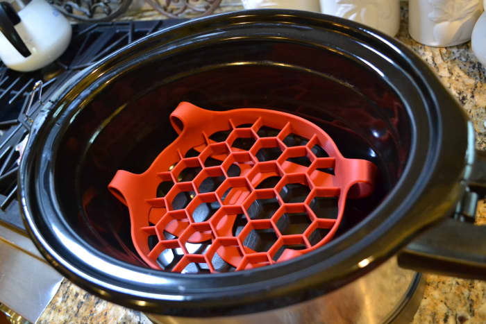 A silicone egg cooker designed for an Instant Pot makes a perfect roasting rack for a crock pot. Folding the egg cooker's handles underneath elevates it just a bit more.
