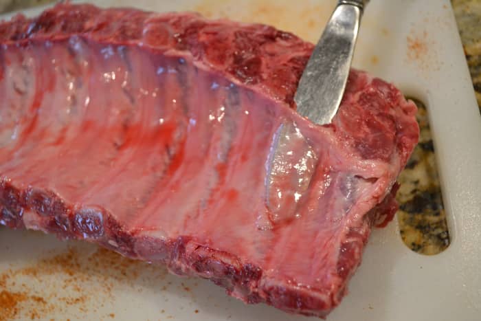 Slide a butter knife under the membrane to lift the membrane up from the meat on one end.