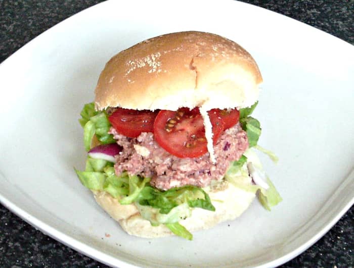 Mashed Corned beef and horseradish sauce is sandwiched with a simple salad and sliced tomato