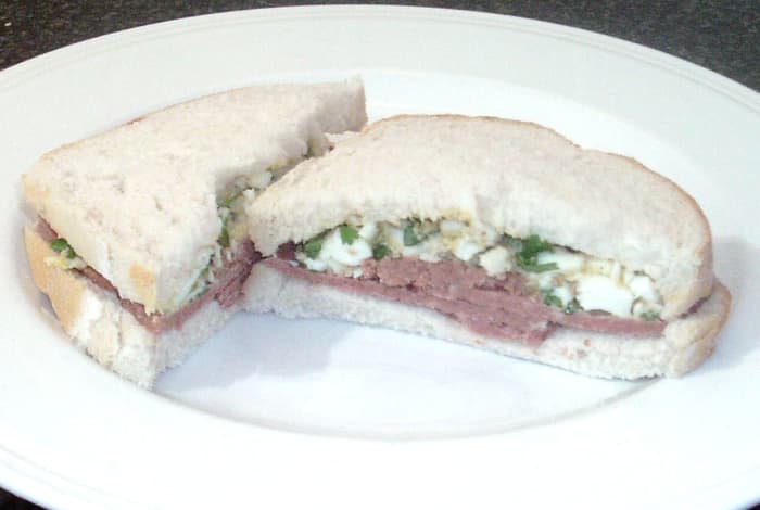 Boiled egg mashed with parsley accompanies the corned beef in this tasty sandwich