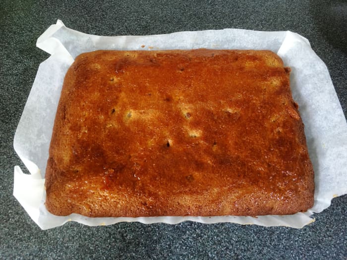 Leaving a good margin of baking paper around your tray will enable you to use the edges as 'handles' to lift out your cooled cake without breaking it.