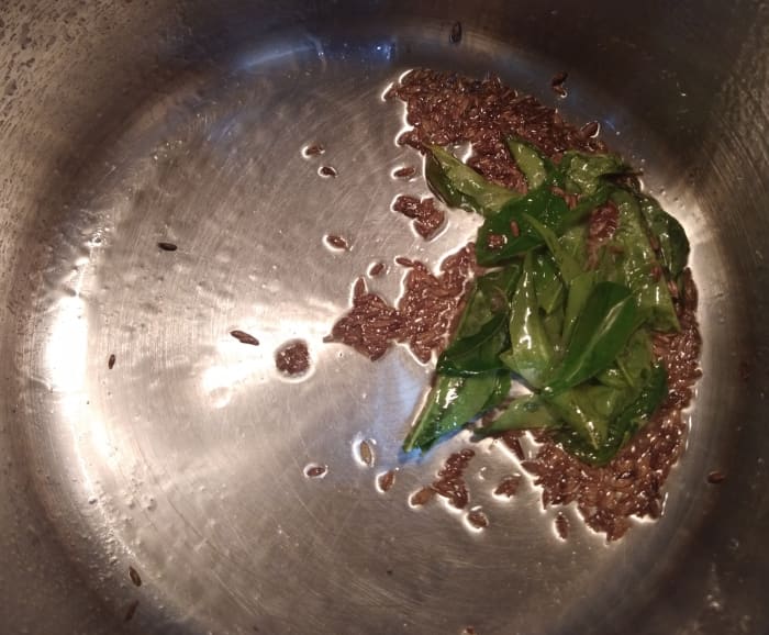 In a pan or pot, heat the oil. Add the cumin seeds and let them splutter. Add the curry leaves and fry.