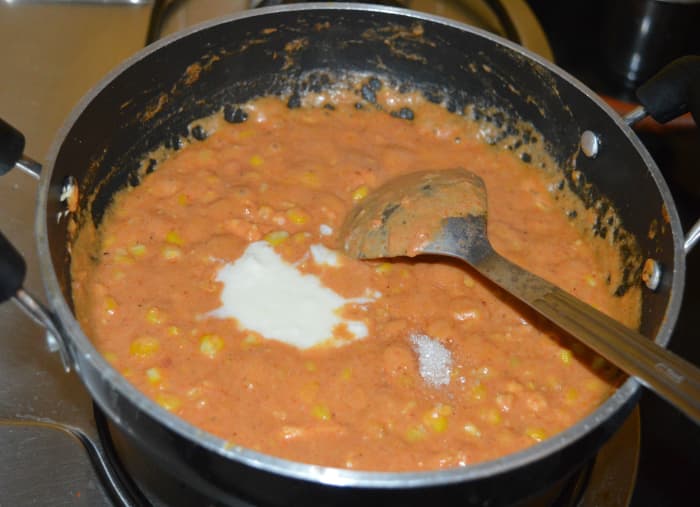 Add yogurt or thick curd, sugar, and remaining salt. Simmer the mixture and continue to cook for a minute. Turn off heat.