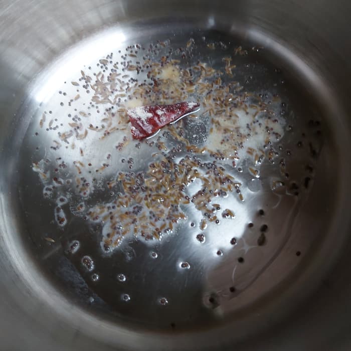 In a pan or vessel, heat the oil and splutter 1/2 teaspoon of mustard seeds and 1/2 tablespoon cumin seeds. Add 1-2 broken red chili and asafoetida. Fry.