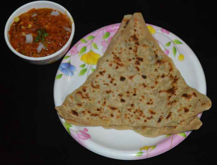 Paneer paratha served with tomato salsa.