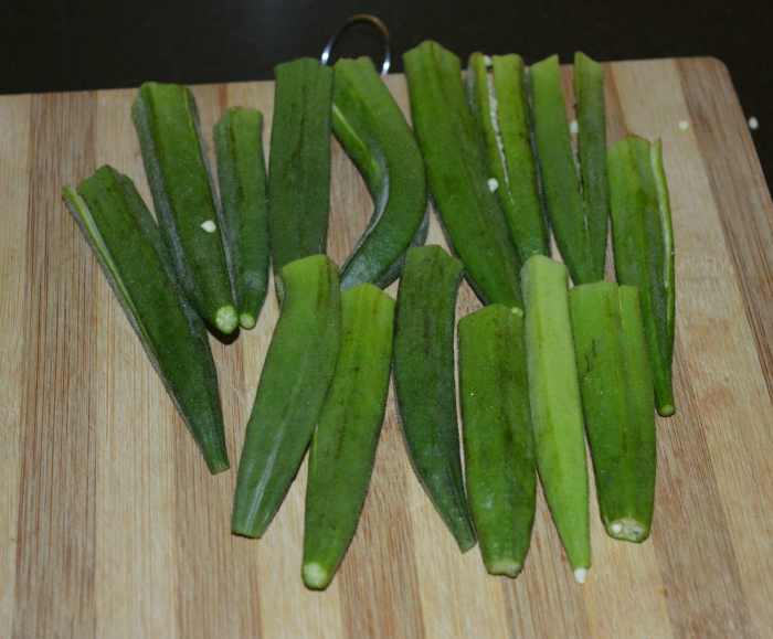 Step four: Chop both the ends of the okra. Discard them. Slit each of the okra vertically.