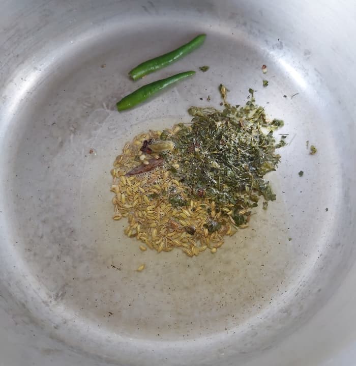Add 1 teaspoon of fennel seeds, 1-2 teaspoons of kasuri methi or dry fenugreek leaves and 1-2 slit green chilies. Fry for a minute.