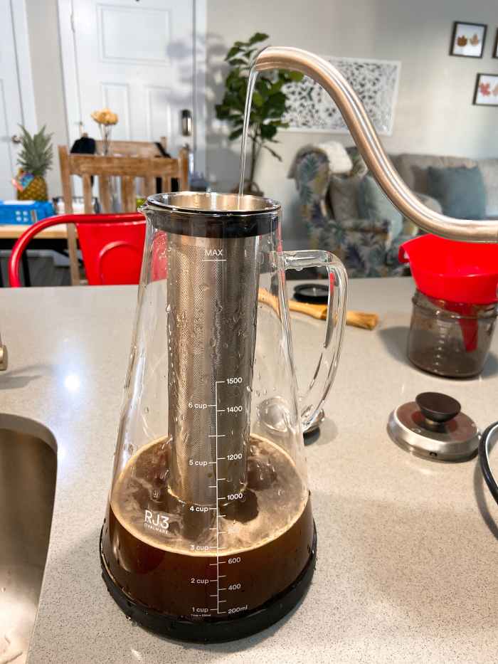 Carefully pour room temperature filtered water over the grounds, filling to the max line.