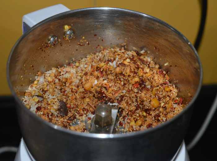 Roasted ingredients added to a mixer jar for making vangibath powder.