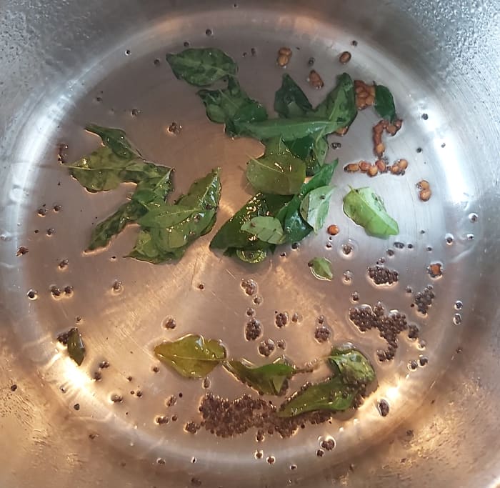 In a pan or pot, heat 1-2 teaspoons of oil, splutter 1/2 teaspoon of mustard seeds, 1/4 teaspoon of fenugreek seeds or methi seeds and 1-2 strings of fresh curry leaves. Fry till curry leaves turn crisp.