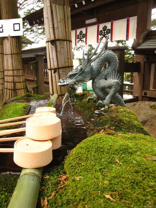 A close up of the ladles and water, both important tools to cleanse yourself before entering a shrine.