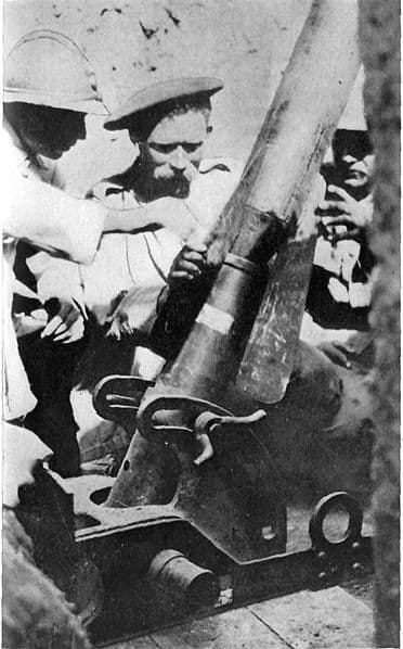 Frenchman instructing Serbian in use of trench mortar. The shell weighs about 100 pounds