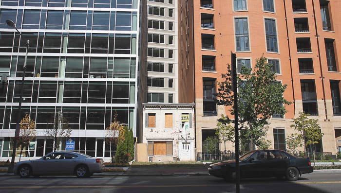 Office blocks to the left, condominiums to the right, and Austin Sprigg's hold-out house in the middle