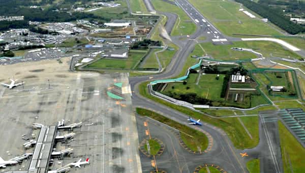 Narita Airport. Note the aeroplanes parked at the terminal on the lower left, the runway at the top, and of course the farmland in the middle of the airport