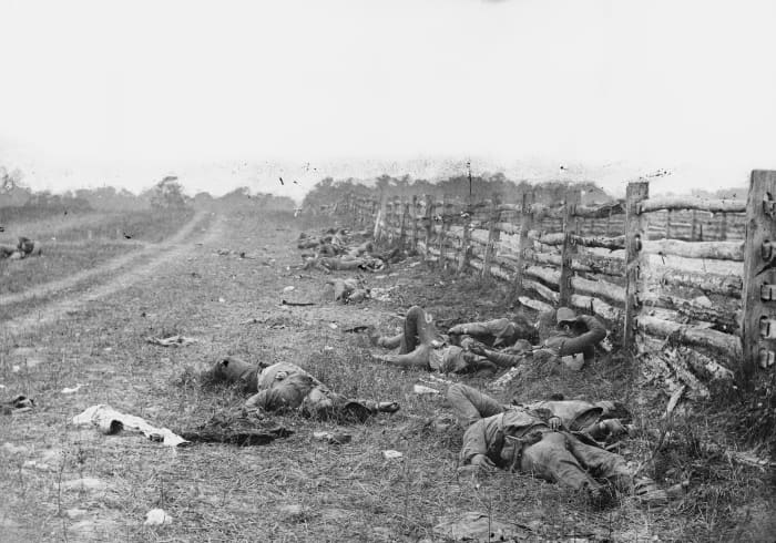 Confederate dead by a fence at the Hagerstown Turnpike, looking north; the Turnpike is to the right of the fence, the dirt lane on the left leads to the farm of David Miller.