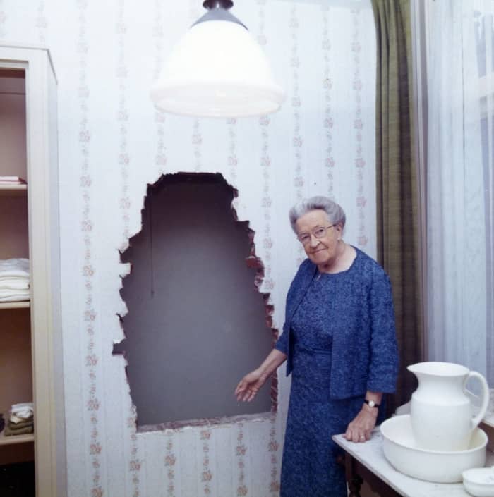 Corrie ten Boom Shown Pointing Out the Entrance to the Hiding Place Behind the Wall in What Had Been Her Bedroom