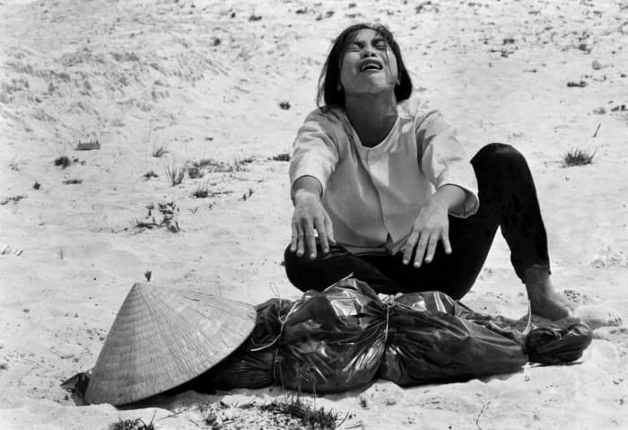 A woman mourns over the body of her husband after identifying him by his teeth, and covering his head with her conical hat. The man’s body was found with forty-seven others in a mass grave near Hue, April 11, 1969.