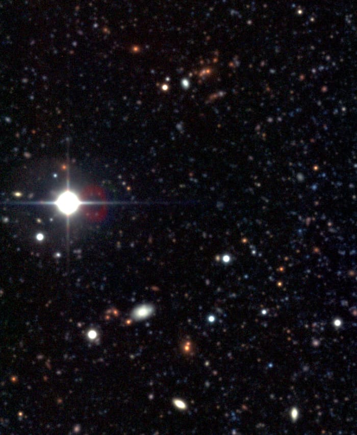 A cluster of galaxies from NGC 300 images. Their red color suggests they are equidistant from each other.