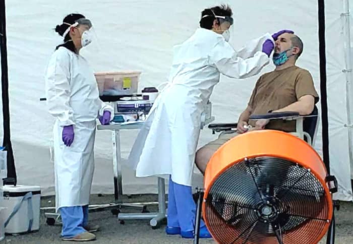 A pic of me participating in COVID-19 research at a tent outside of UNC after I tested positive for COVID-19. The doctor is inserting a swab into my nose to collect a sample. Needless to say, it felt really strange.