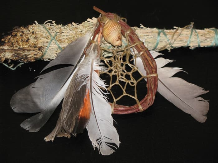 A traditional dream catcher and a smudge stick that is used to spread ceremonial cleansing fragrances in a dwelling or longhouse.