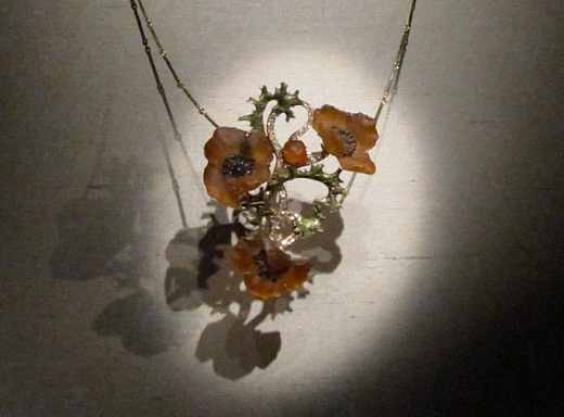 A delicate poppy necklace made in the early 1900s by René Lalique. It is gold, diamonds, enamel and glass.