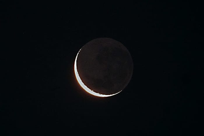When there is a crescent Moon with little sunshine illuminating the daylit part of the near side, the very faint glow of earthshine - sunlight reflected off the Earth on to the night side of the Moon's disc - is apparent