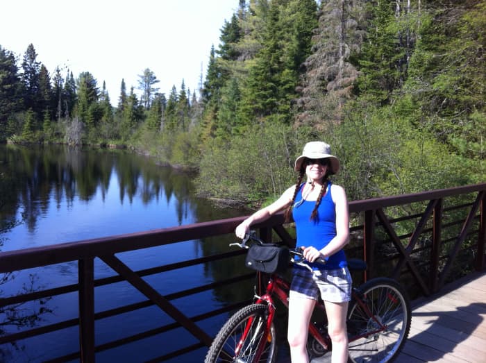 The author, Jessica, taking a break from mountain biking to enjoy the view. Taken along the bike trails of Mew Lake campground, Algonquin Park.