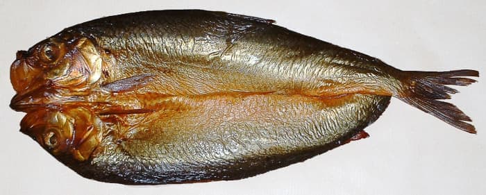 This is a split, gutted, and smoked kipper, which is a type of herring. Kippers that are completely red have often been colored artificially to shorten the smoking time.